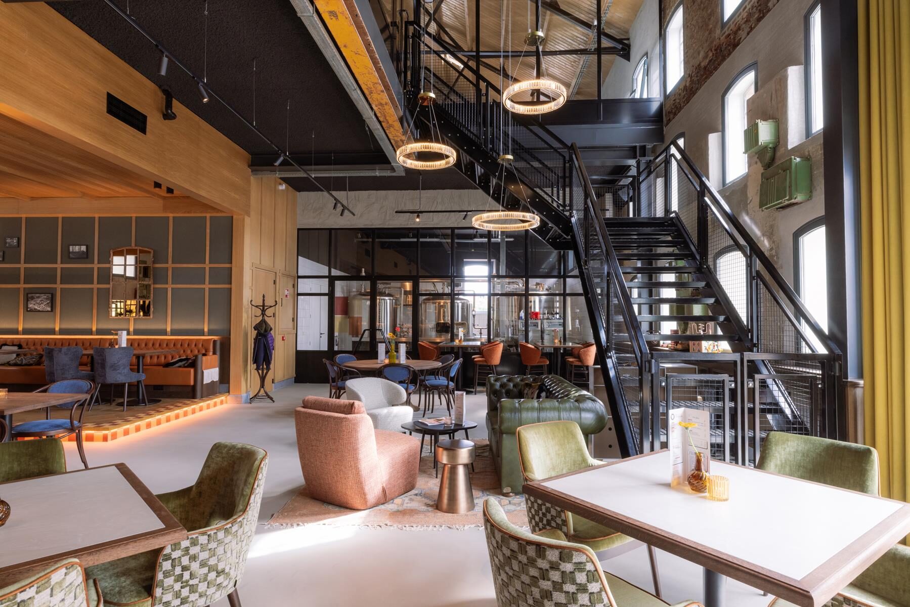 Interieur van Brouwerij & Gastropub De Valk op De Pannenfabriek in Echt, met zithoeken en de trap naar de eerste verdieping