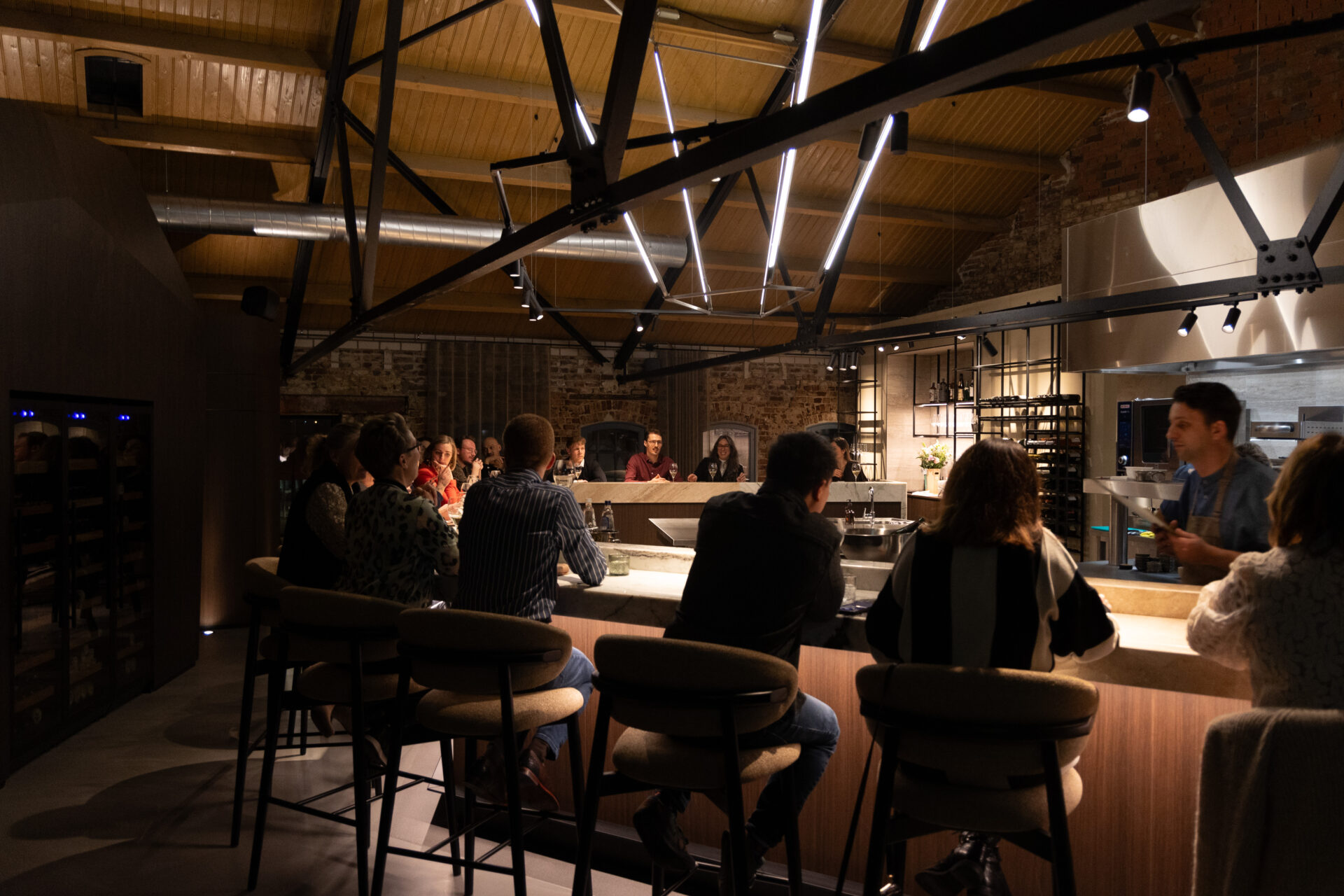 Groep aan de bar met open keuken op De Pannenfabriek in Echt
